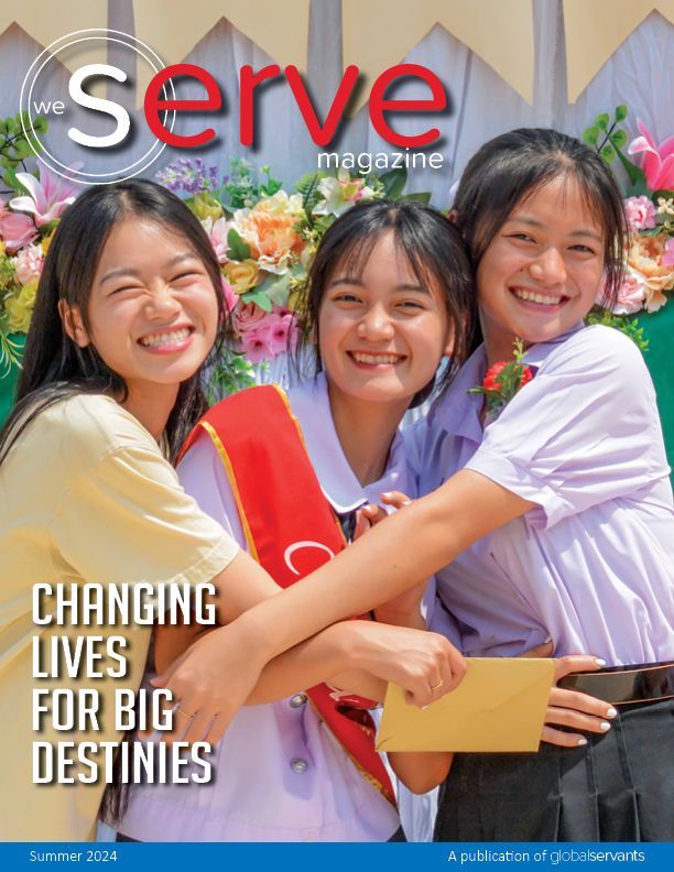 Three girls are hugging each other on the cover of a magazine.