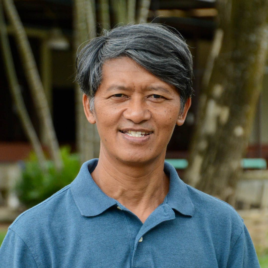 A man in a blue shirt is smiling for the camera.