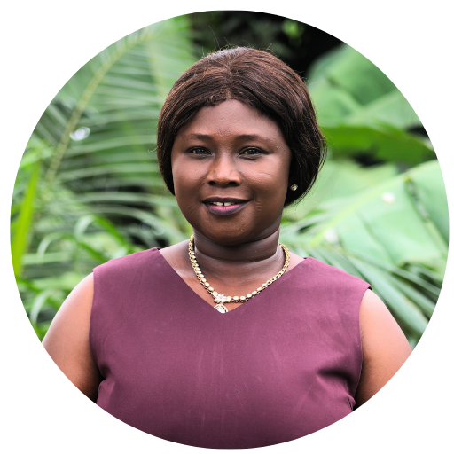 A woman wearing a red shirt and earrings is smiling for the camera.