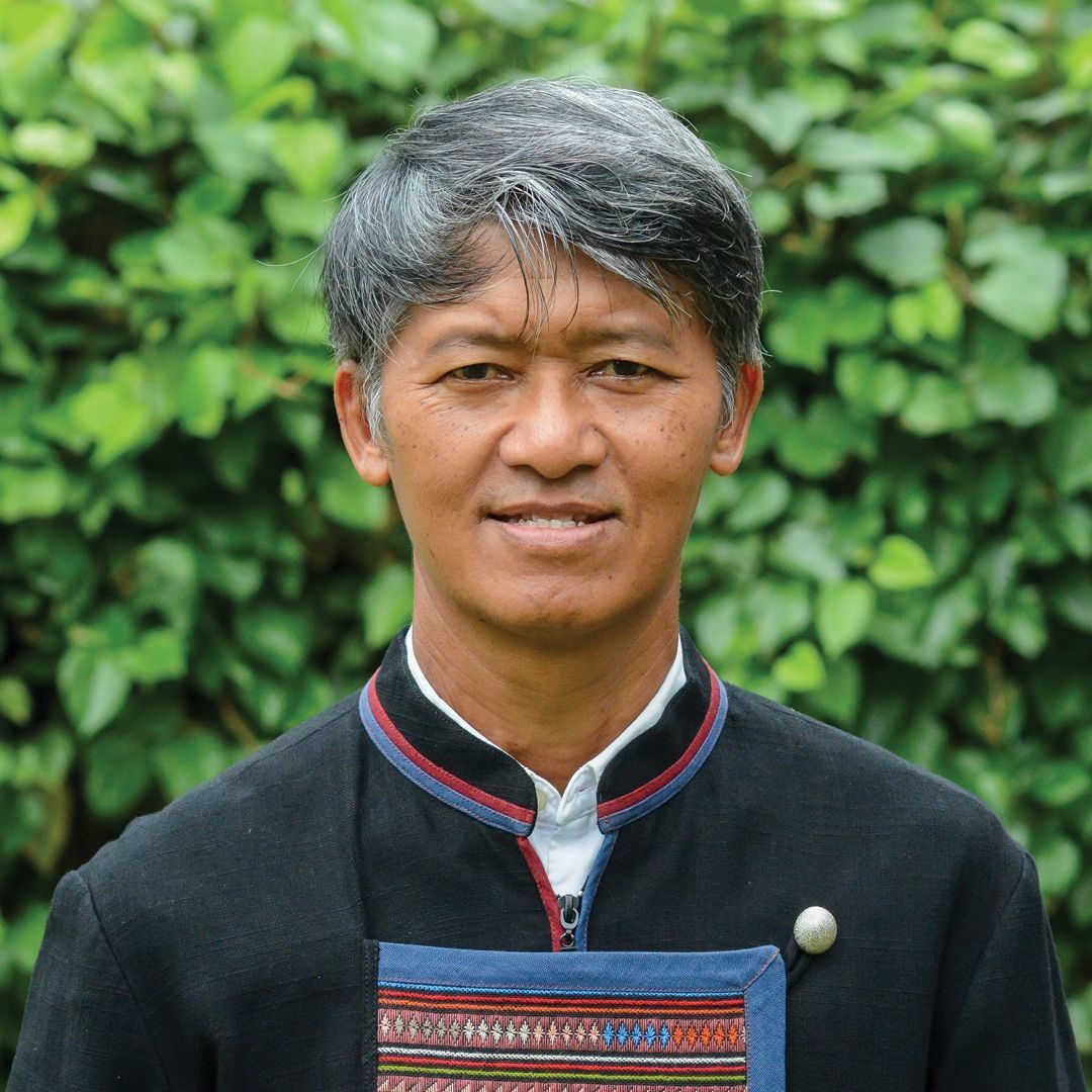 A man in a blue shirt is smiling for the camera.