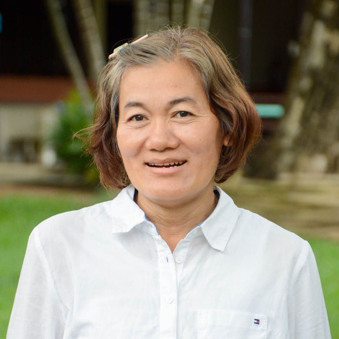 A woman in a white shirt is smiling for the camera.