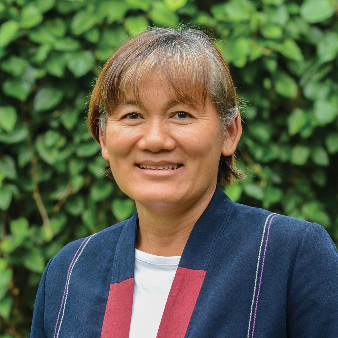A woman in a white shirt is smiling for the camera.