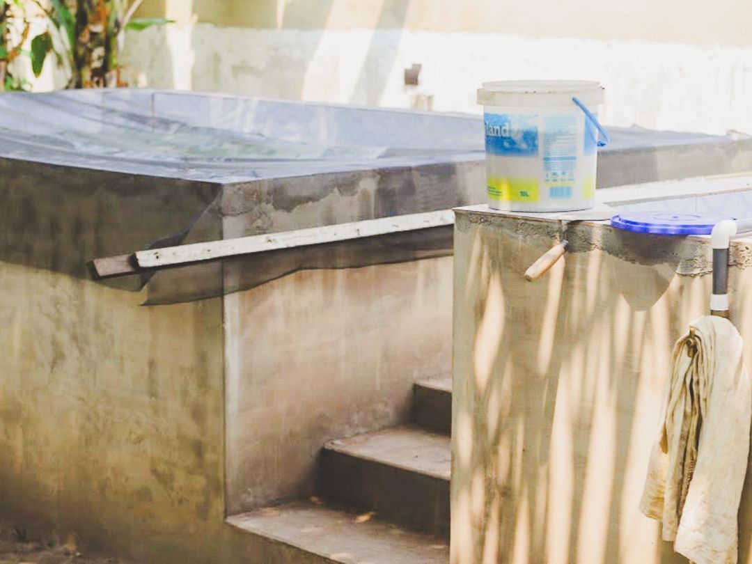 Concrete water tanks with steps and a bucket.