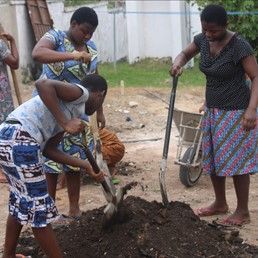 Women digging a hole with shovels at House of Grace Ghana