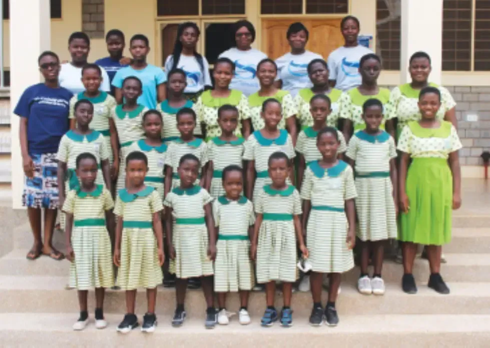 A group of children posing for a picture in front of a building