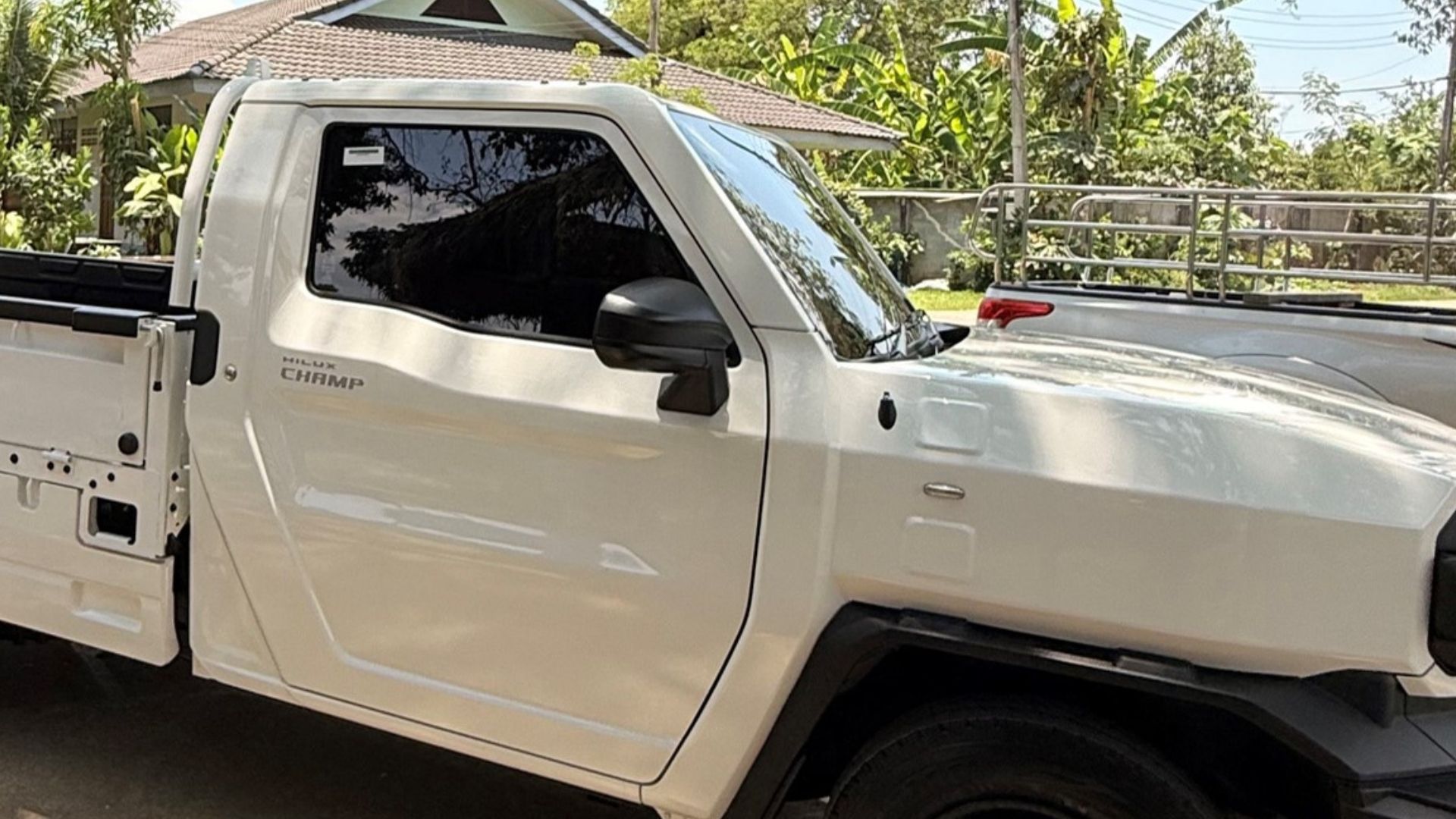White pickup truck parked outside on a sunny day.