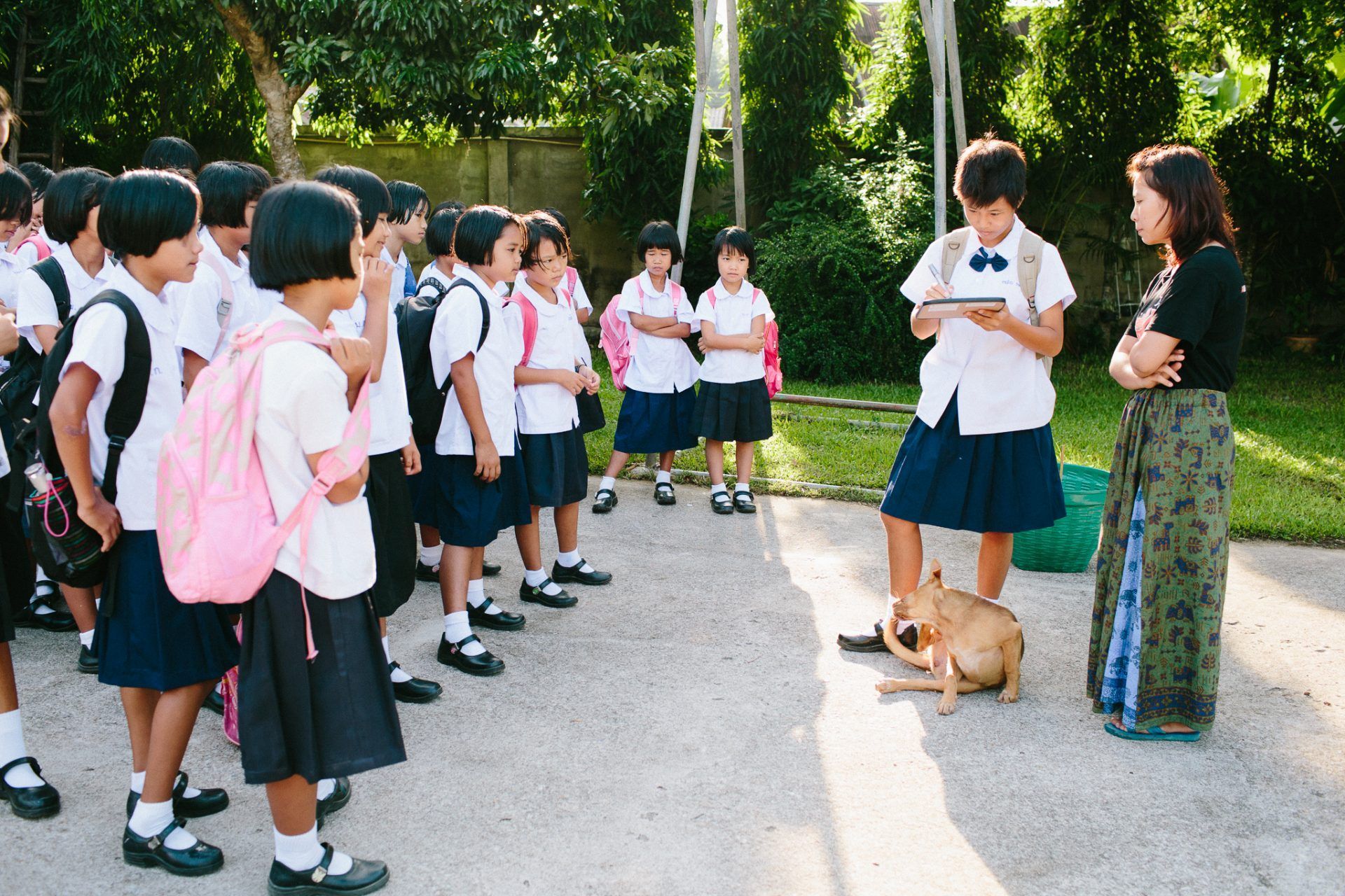 A woman is standing in front of a group of children