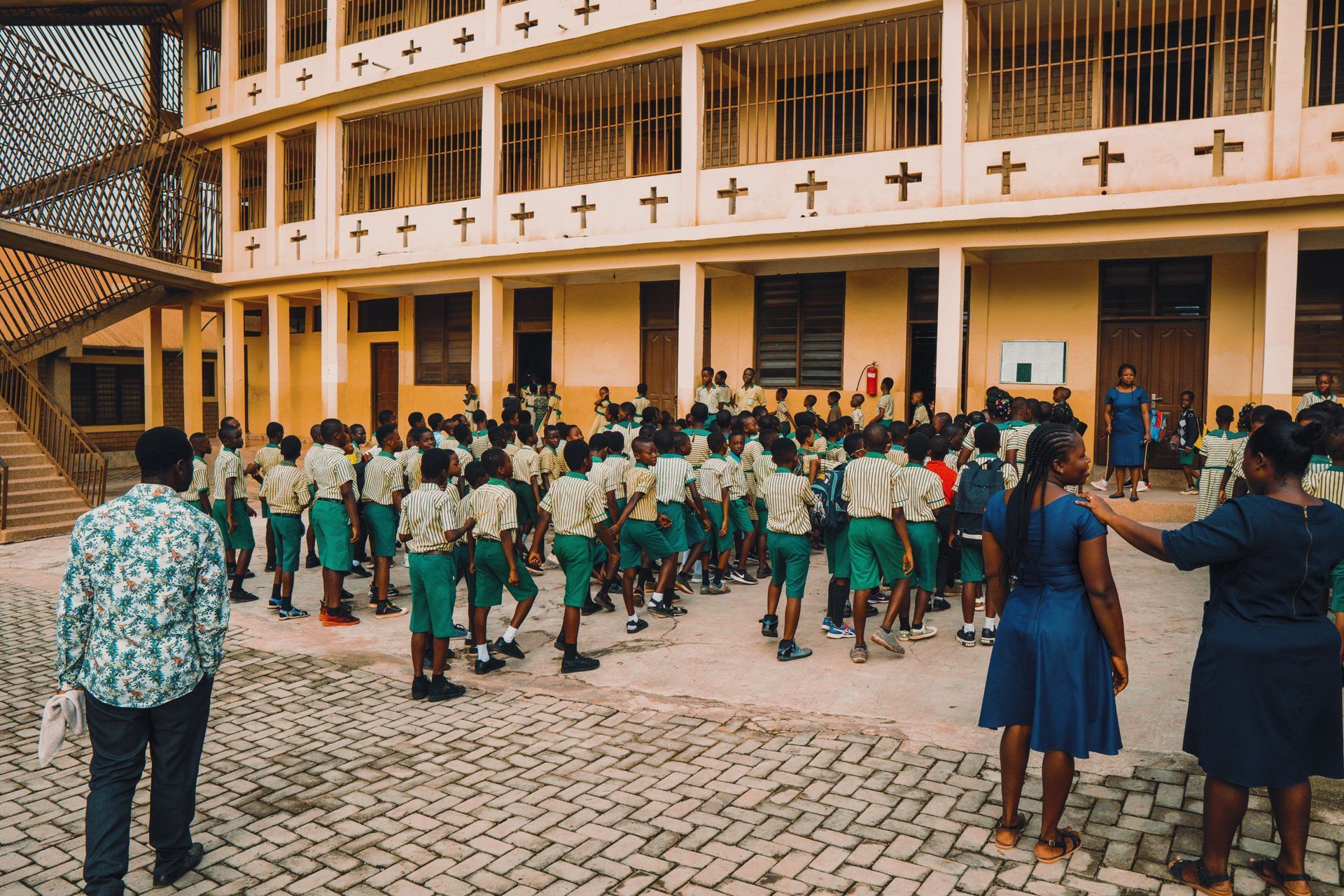 A group of children are standing in front of a large building.