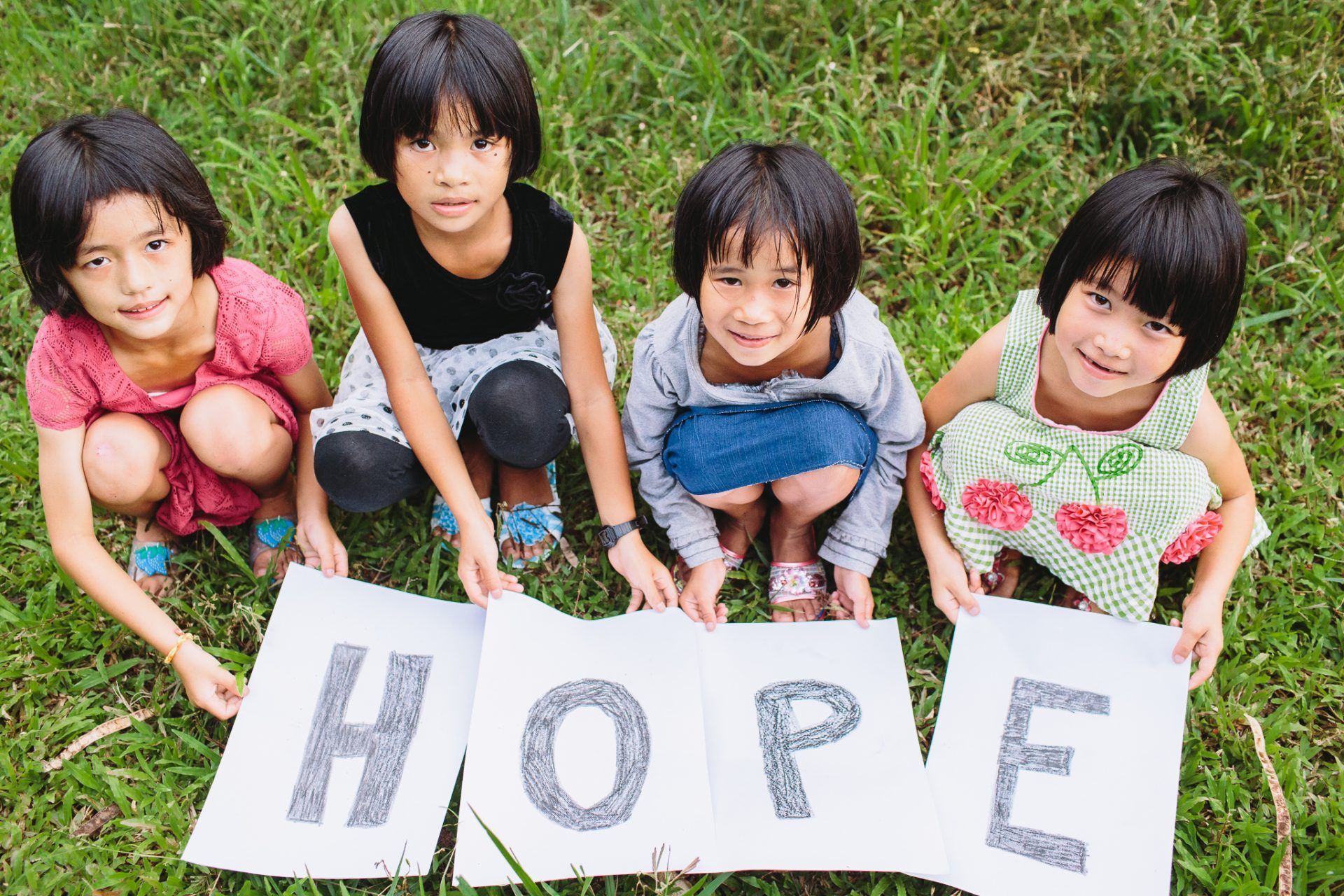 Four little girls are holding a sign that says hope