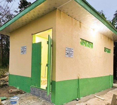 A small yellow and green building with a door open