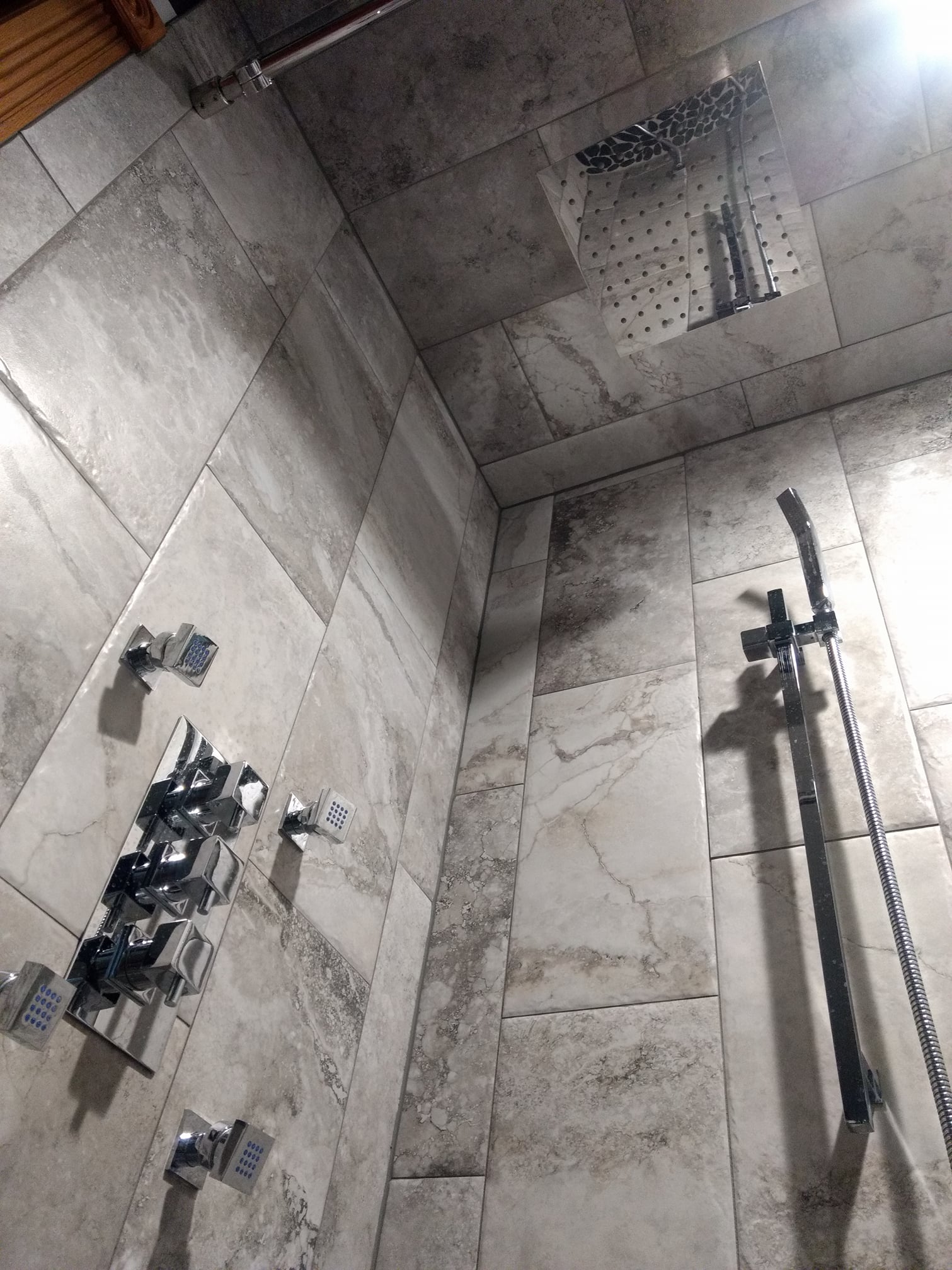 a shower with a lot of tiles and a shower head