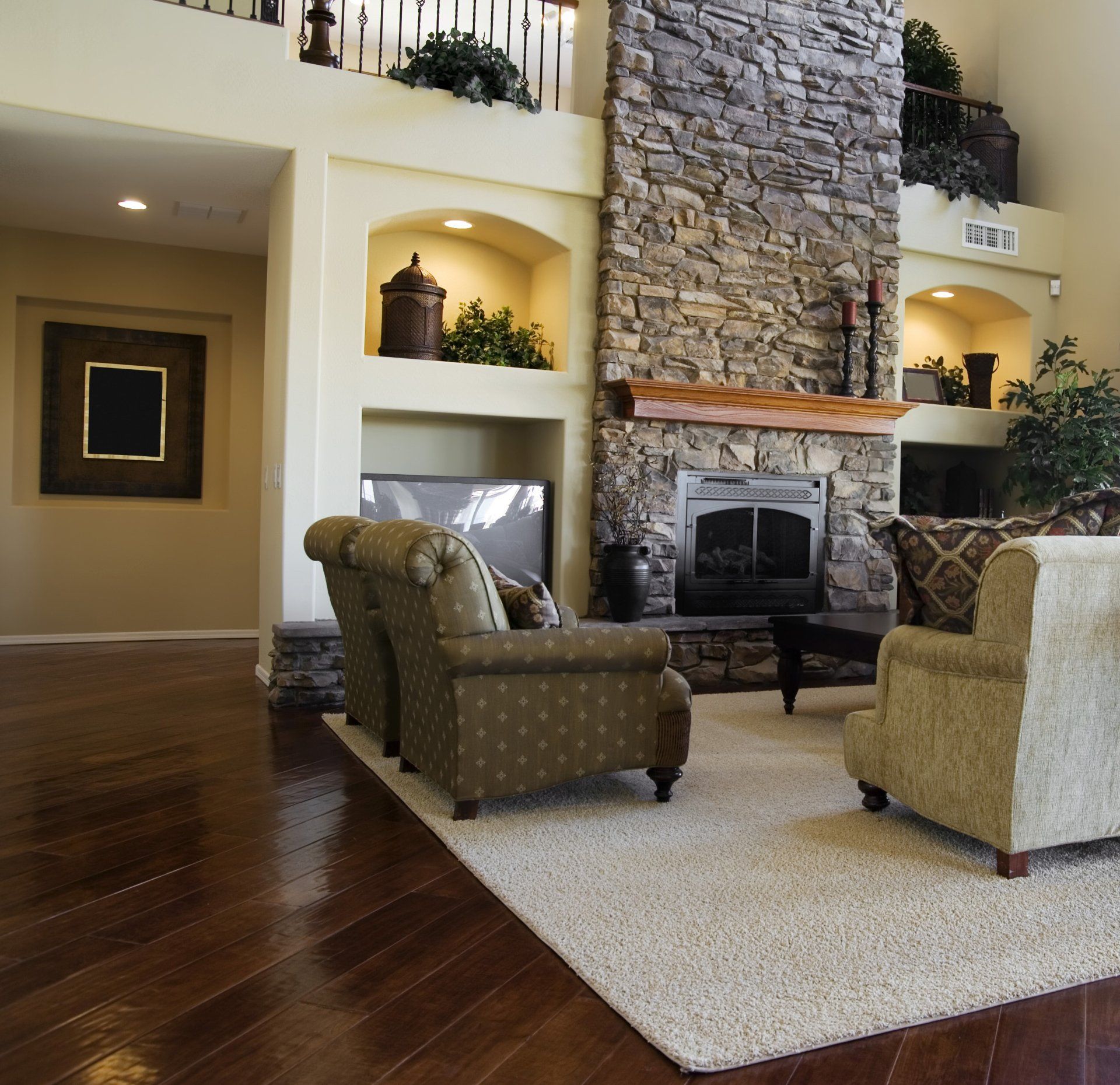 a living room with a stone fireplace and chairs