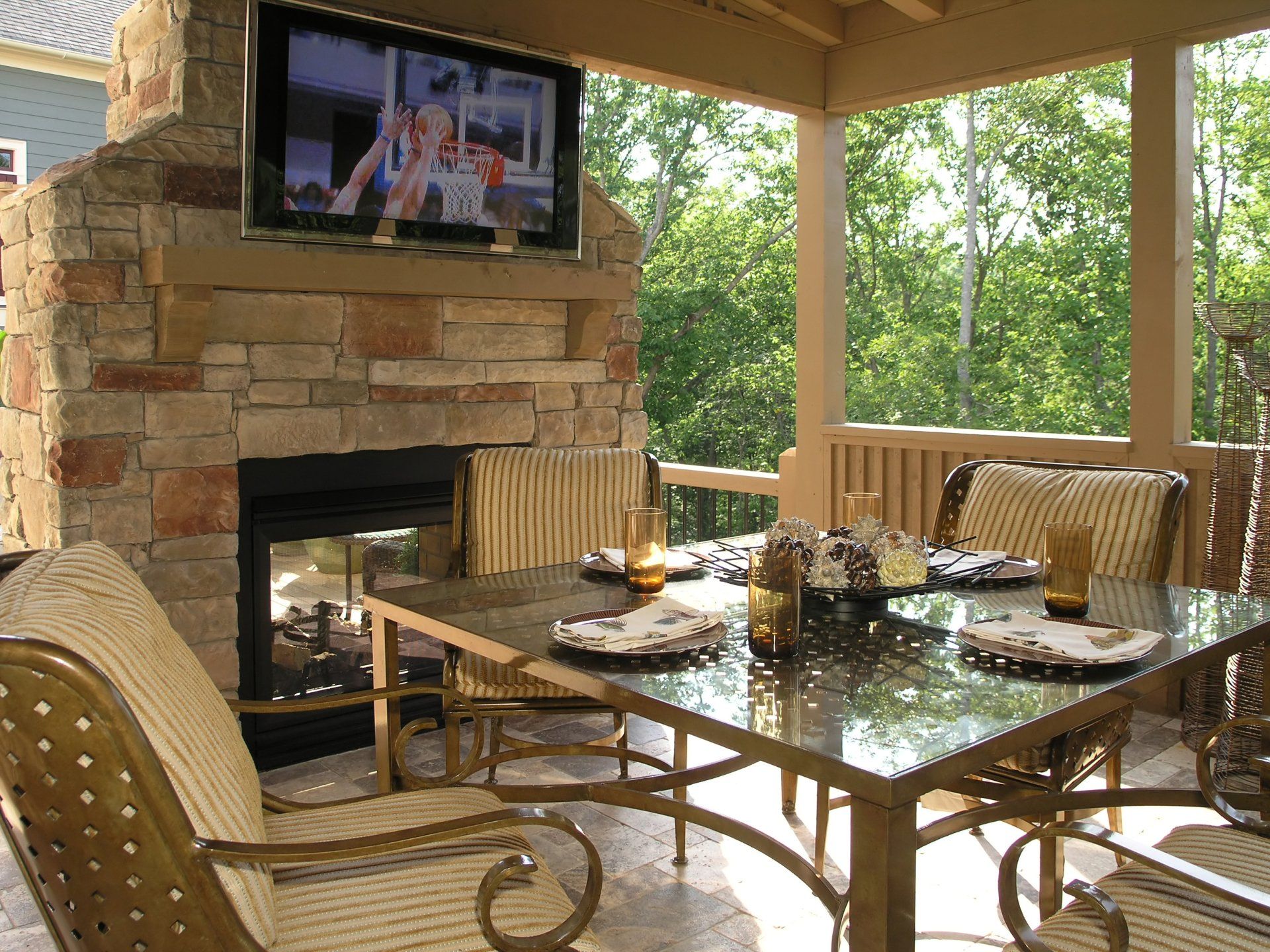 a patio with a fireplace and a flat screen tv above it