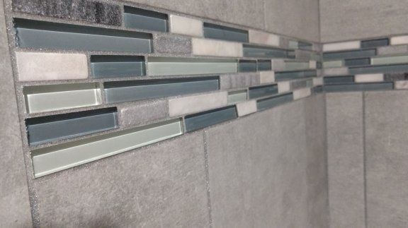a close up of a tiled wall in a bathroom .