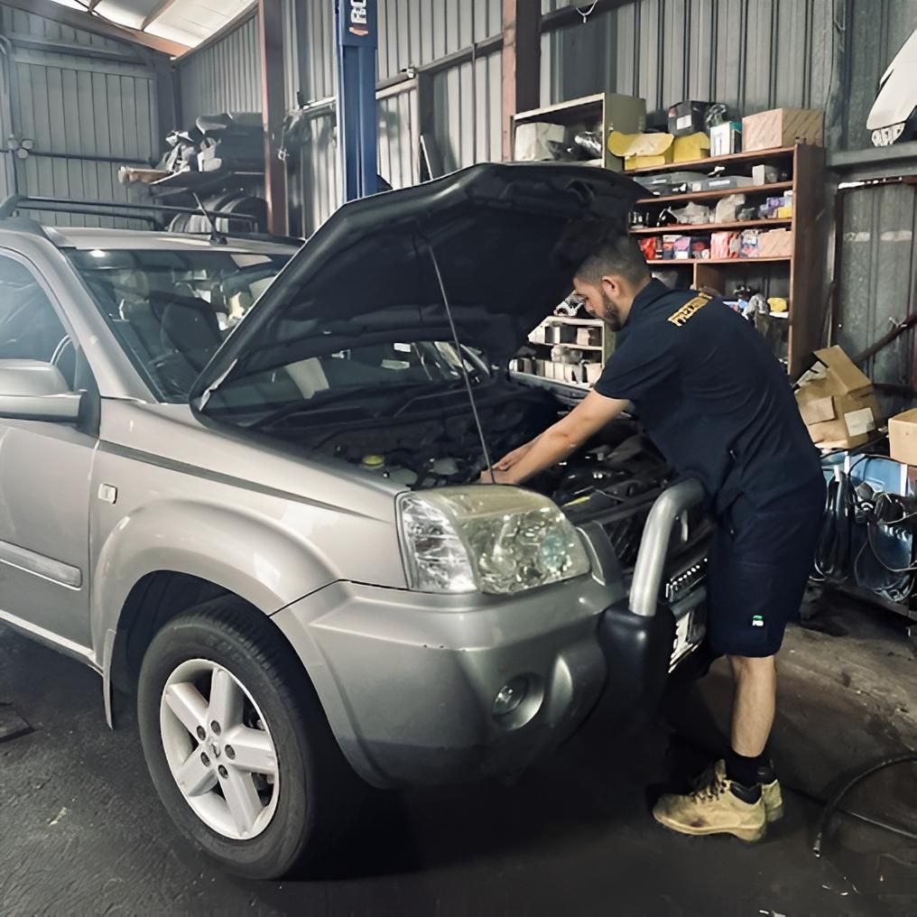 A Man Is Working On A Car In A Garage With The Hood Open — Precision Tuning In Bungalow, QLD