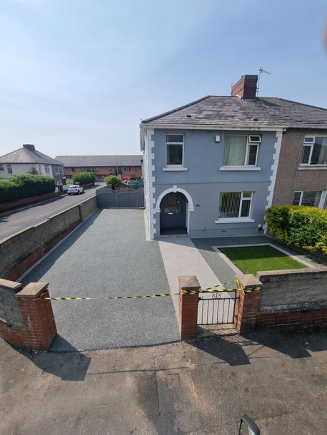 A grey house with a resin bound driveway