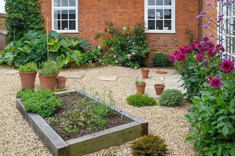 A brick house with a gravel garden in front of it