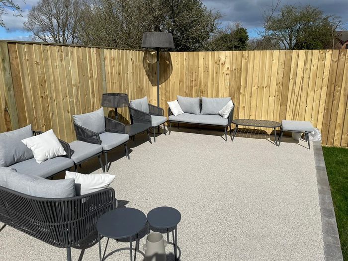 A grey resin patio area with seating in Cambridge