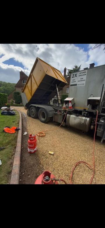 A tipper unloading tar and chip onto a driveway in Cambridge