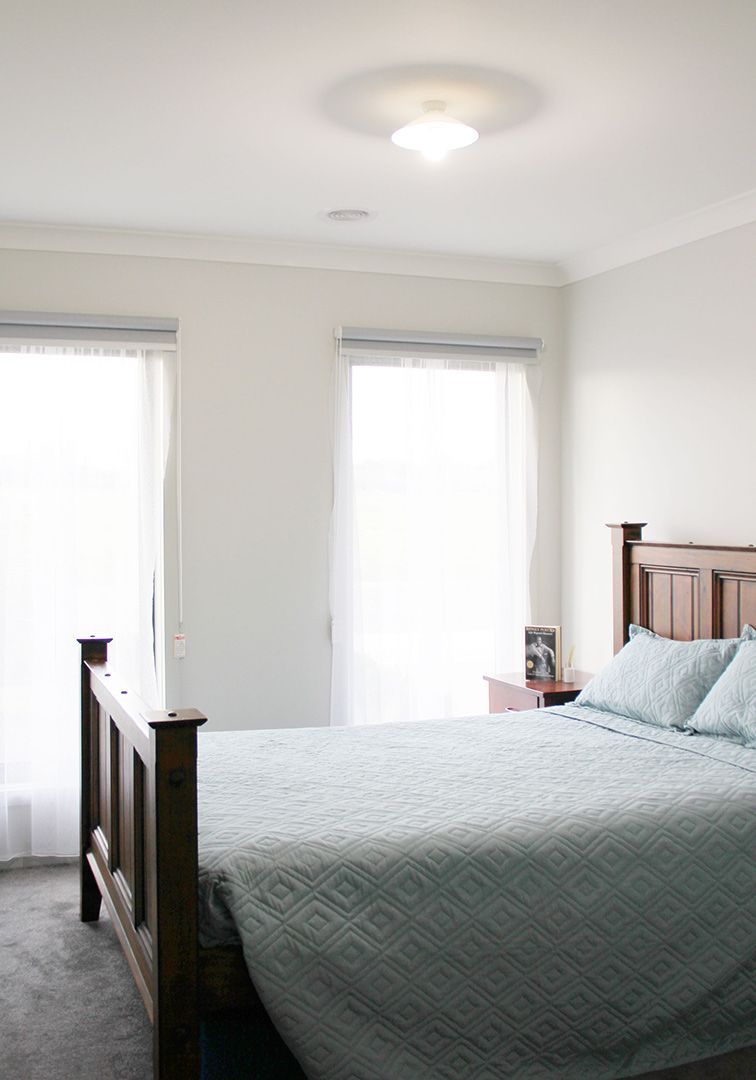 A Bedroom With A Bed, Nightstand, And Sliding Glass Doors — GPM Care Services In Warrnambool, VIC