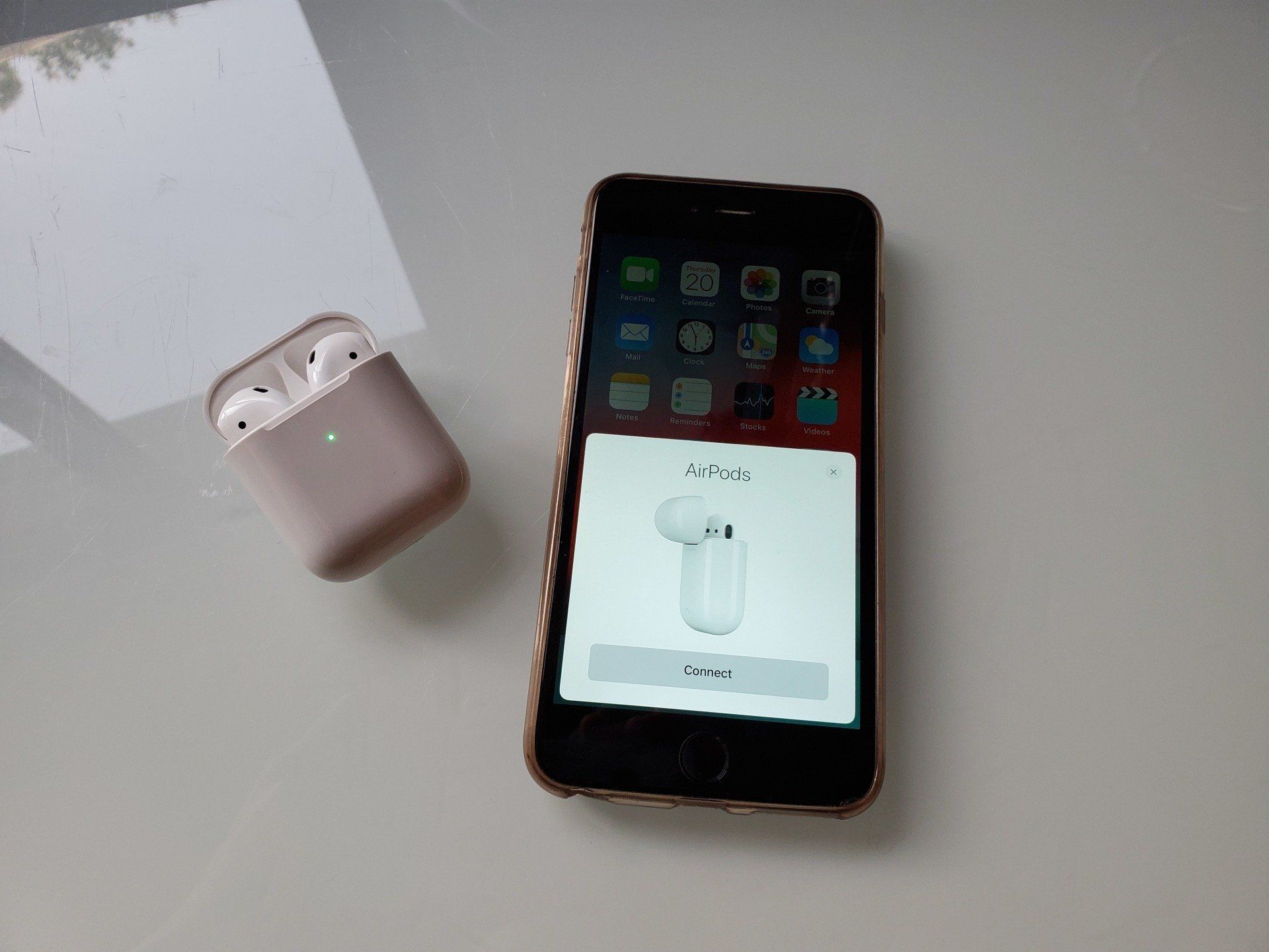 AirPods next to an iPhone, with the menu setup screen.