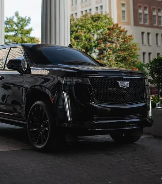 Black Cadillac Escalade ESV parked by a columned building