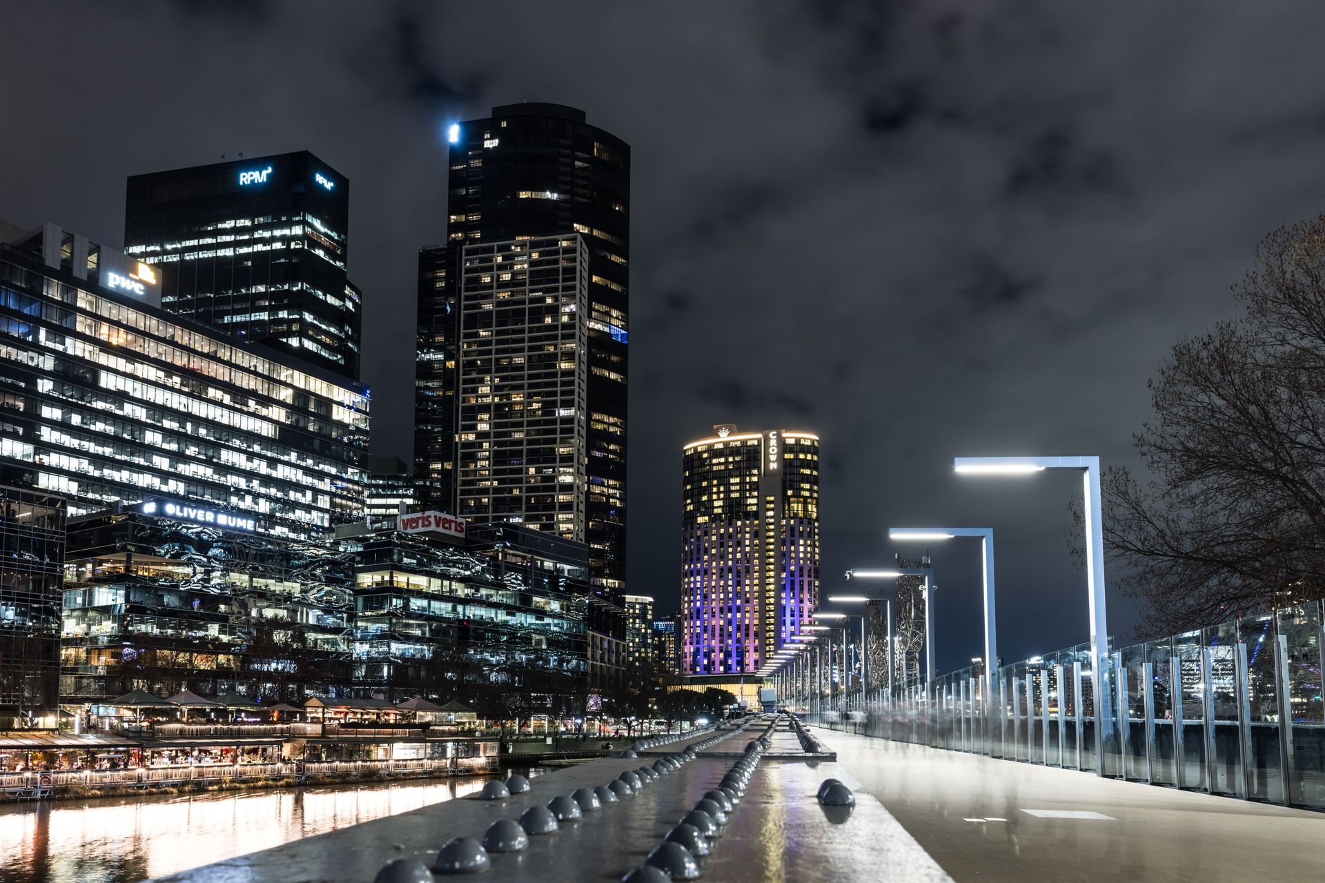 Cloud Gate sculpture reflects the Chicago skyline under a clear blue sky, with the city reflected in a foreground puddle.