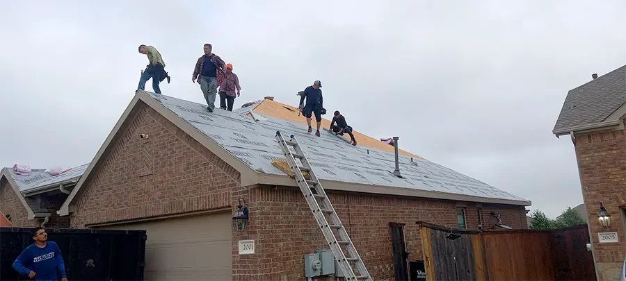 A group of people are working on the roof of a house.