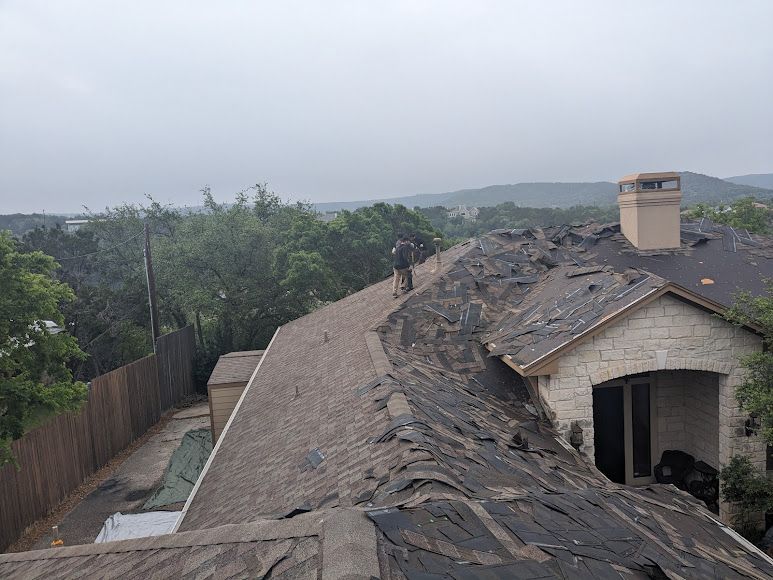 A man is standing on the roof of a house.