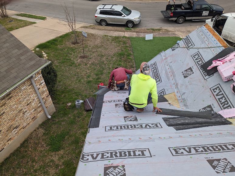A group of men are working on a roof with everbilt shingles.