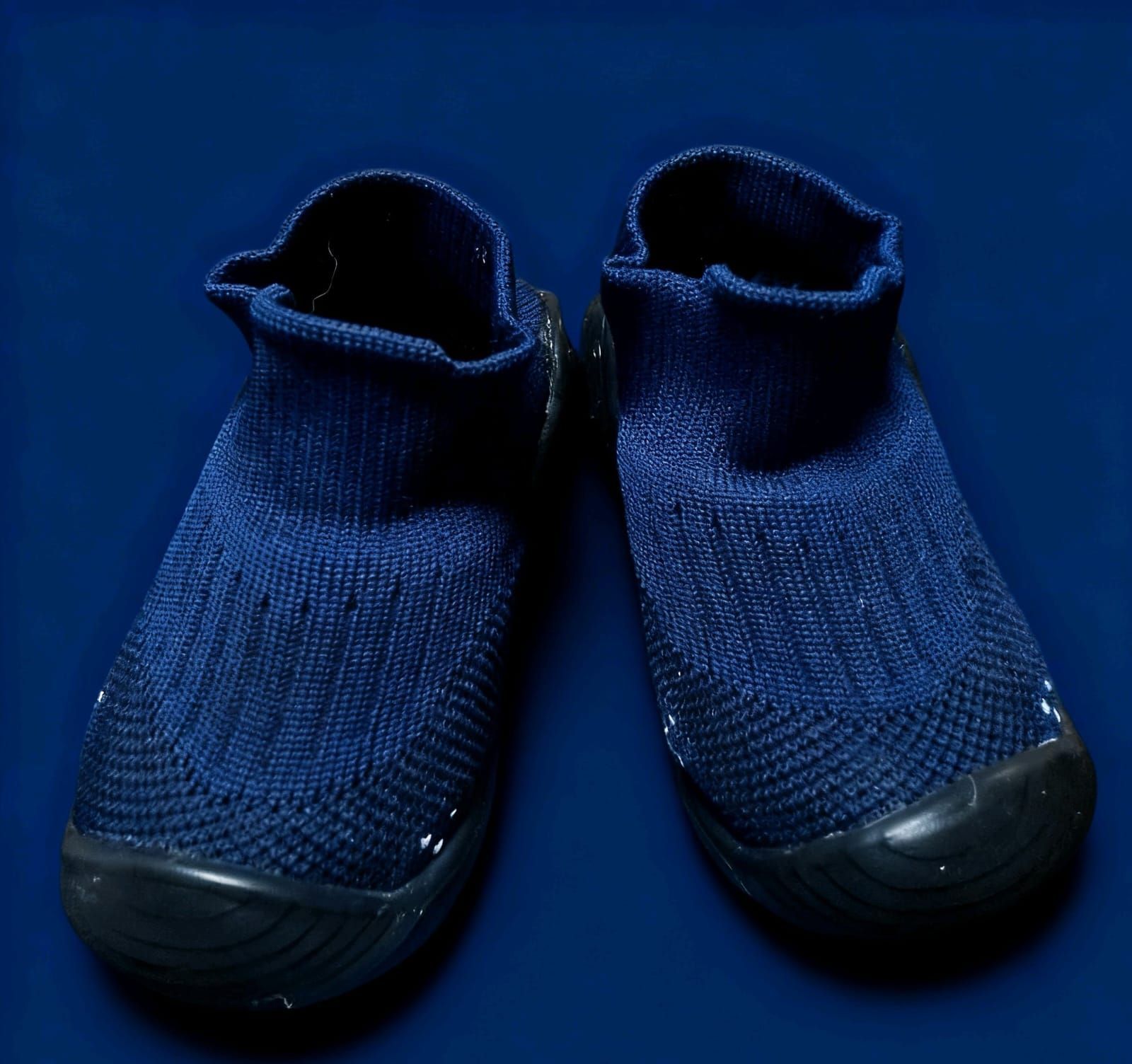 Un par de zapatos sin cordones de color azul oscuro con puntera de goma negra