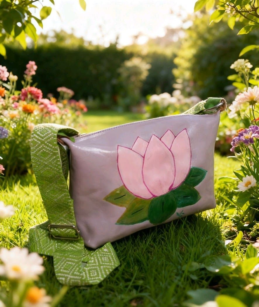 Un bolso bandolera de color lavanda con una aplicación de flor de loto rosa