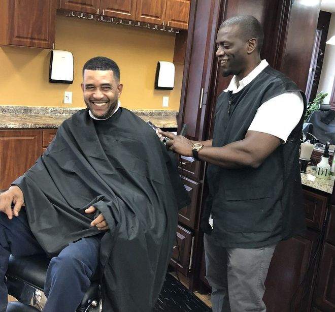 A man is getting his hair cut at a barber shop