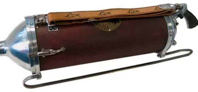 A vintage cylindrical Lux fire extinguisher with a red body, chrome ends, a leather strap, and a pistol-grip handle.