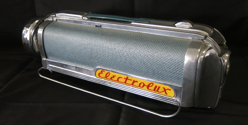 A vintage, cylindrical Electrolux vacuum cleaner canister with a teal, textured surface and polished chrome accents.