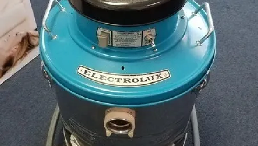 A teal Electrolux canister vacuum cleaner with a metal handle, viewed from above.