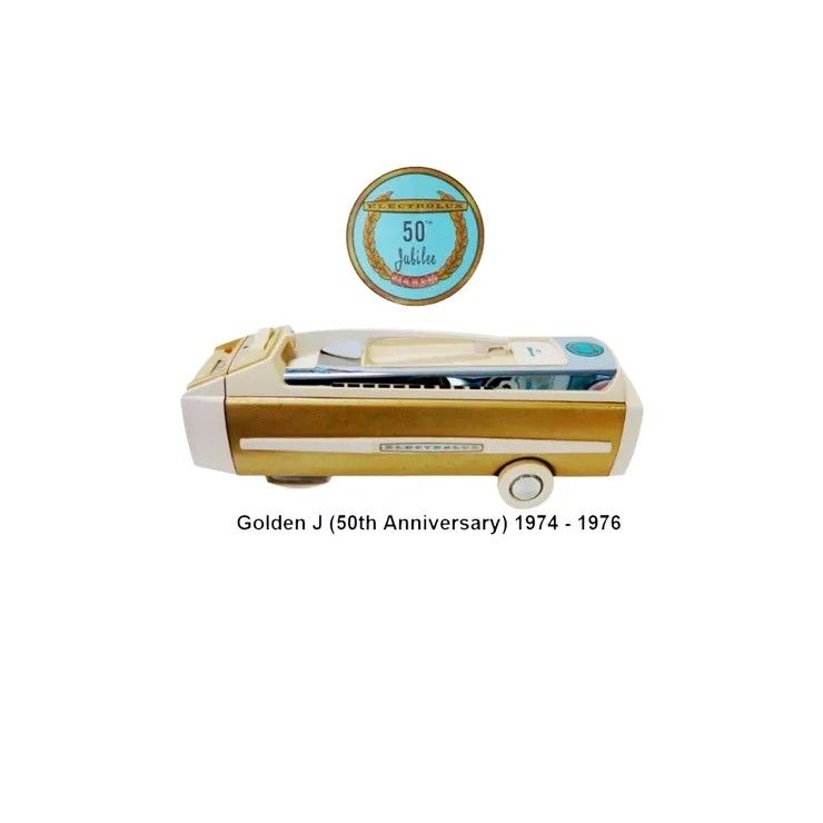 A golden J-model vacuum from 1974-1976 with a 50th-anniversary circular emblem above it.