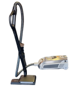 A silver and grey canister vacuum cleaner with a hose, upright wand, and cleaning head against a white background.