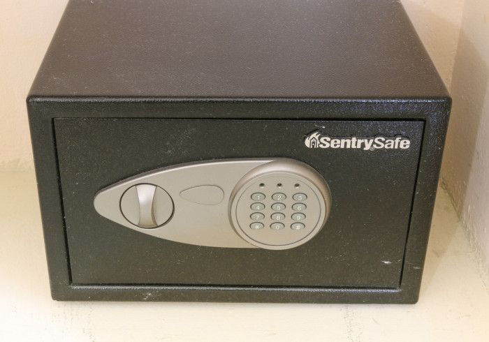 Black SentrySafe digital safe with keypad and dial on a surface.