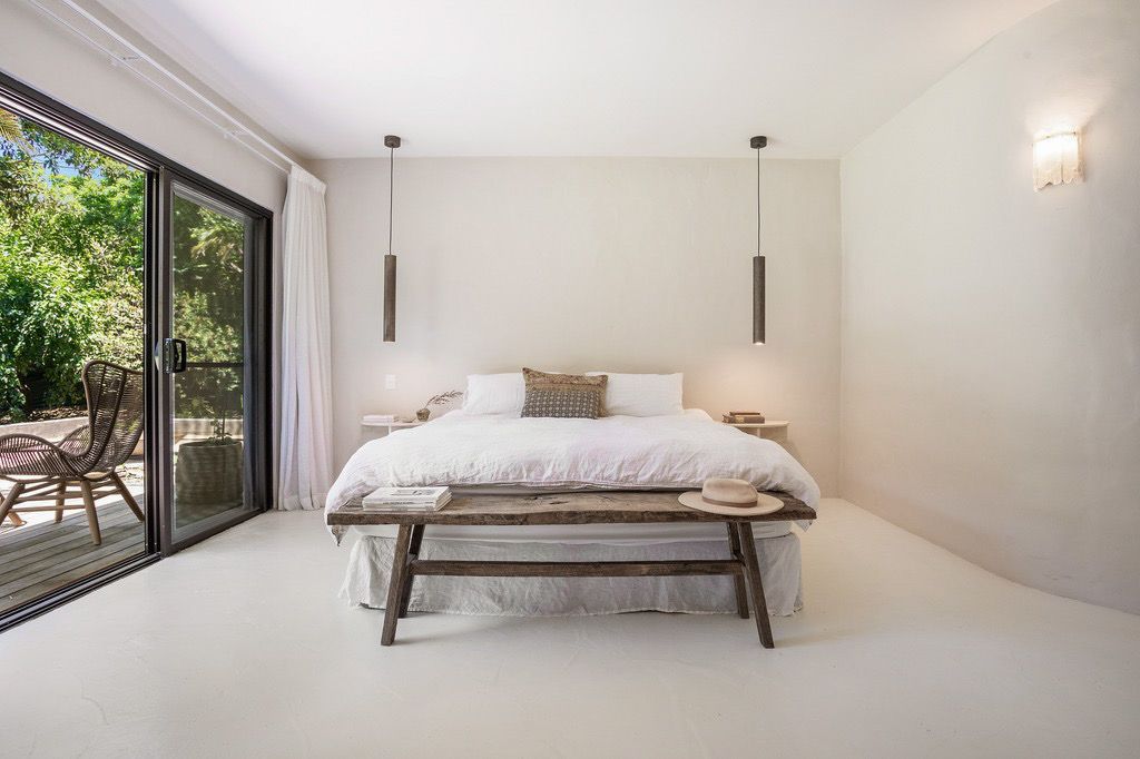 A Bedroom With A King Size Bed, Bench And Sliding Glass Doors — AH Electrical in Casino, NSW