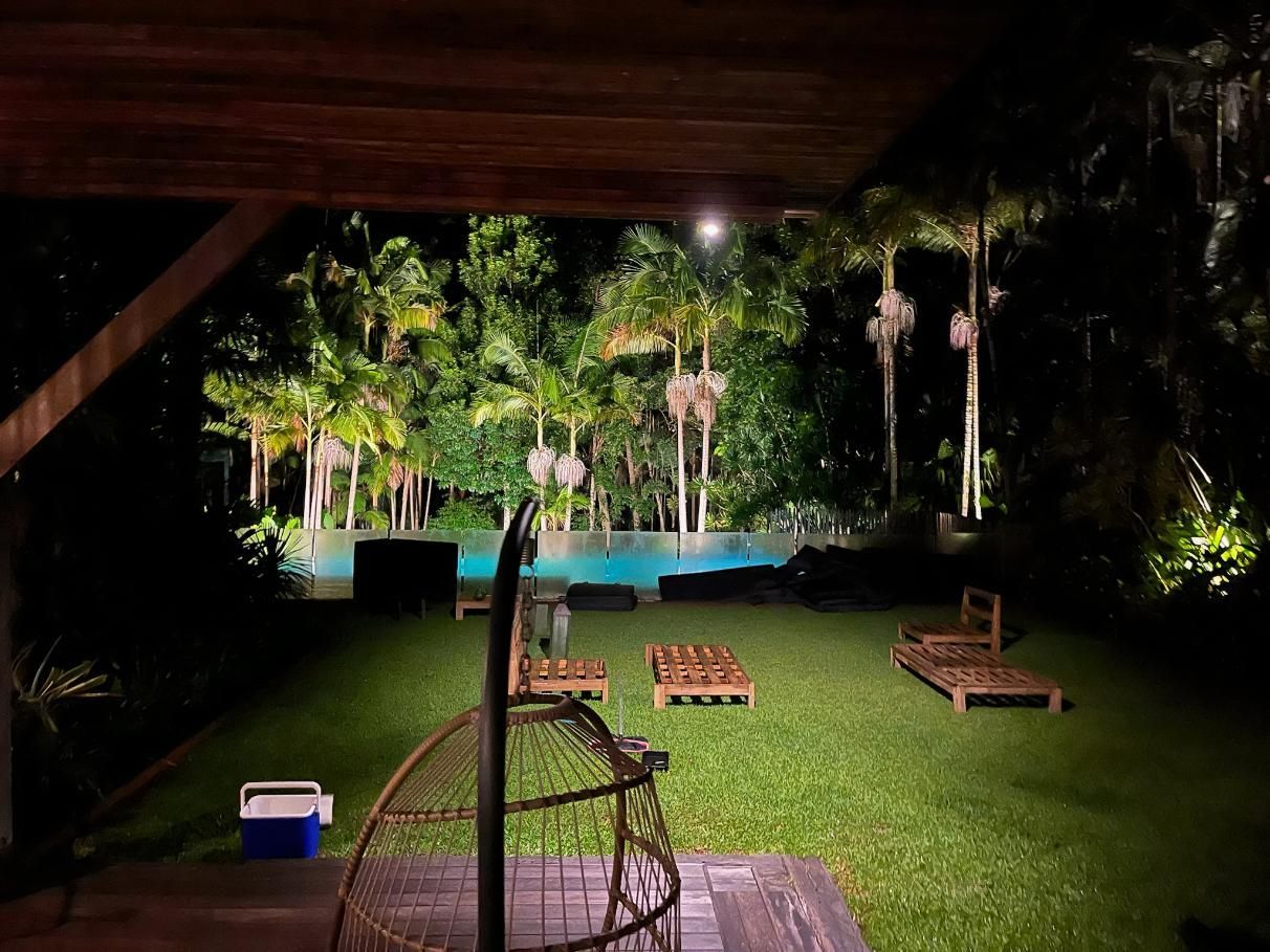A Large Lawn With A Swimming Pool In The Background At Night — AH Electrical in Wollongbar, NSW