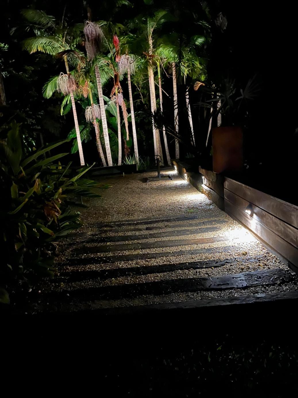 A Staircase Leading Up To A Lush Green Forest At Night — AH Electrical in Lennox Head, NSW