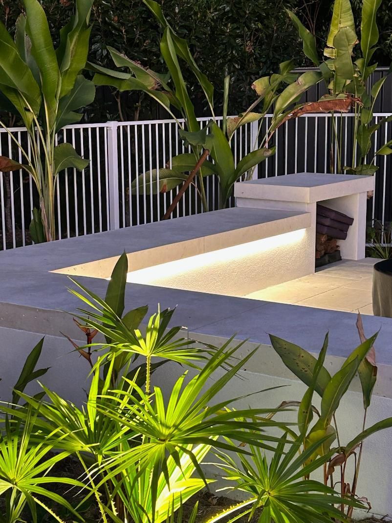 A Fence With A Bench And Plants In Front Of It — AH Electrical in West Ballina, NSW