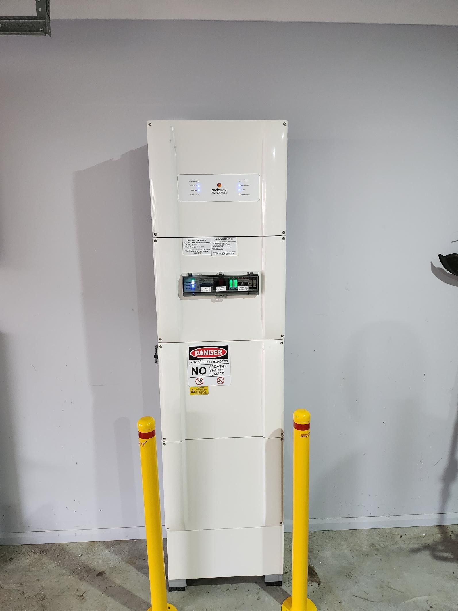 A White Refrigerator Is Sitting In A Room Next To Yellow Poles — AH Electrical in Kyogle, NSW