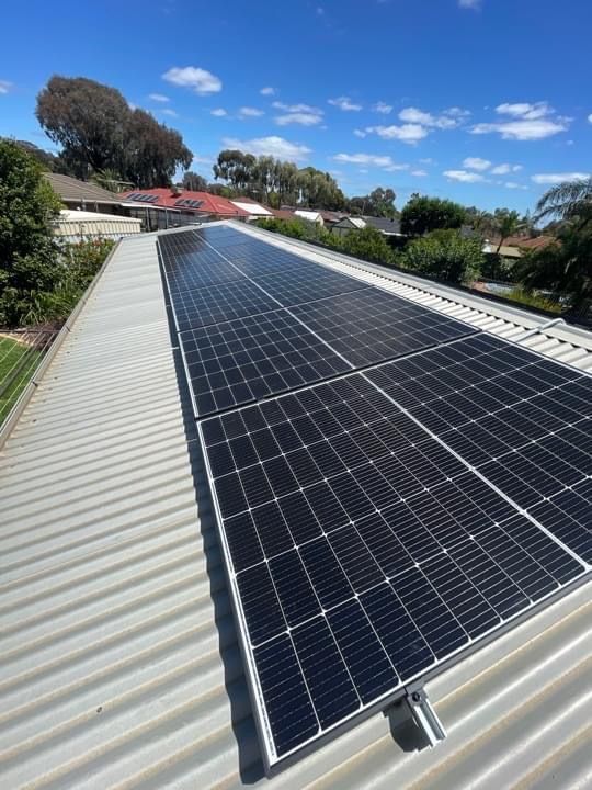A Large Amount Of Solar Panels Are Sitting On Top Of A Roof — AH Electrical in West Ballina, NSW
