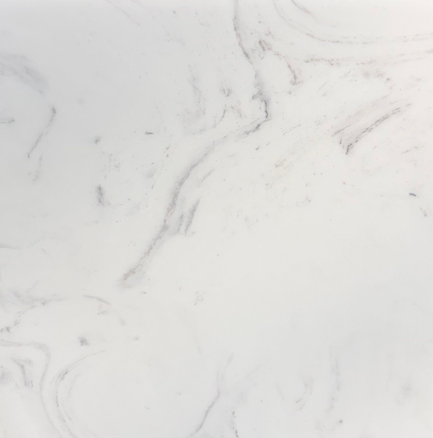A close-up view of white marble stone with faint, soft grey veining throughout the smooth, polished surface.