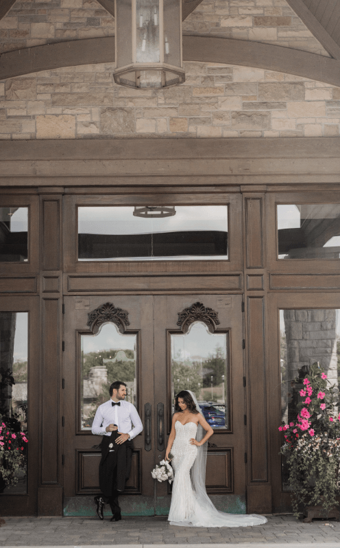 Married couple in front of the large wooden doors to the great hall