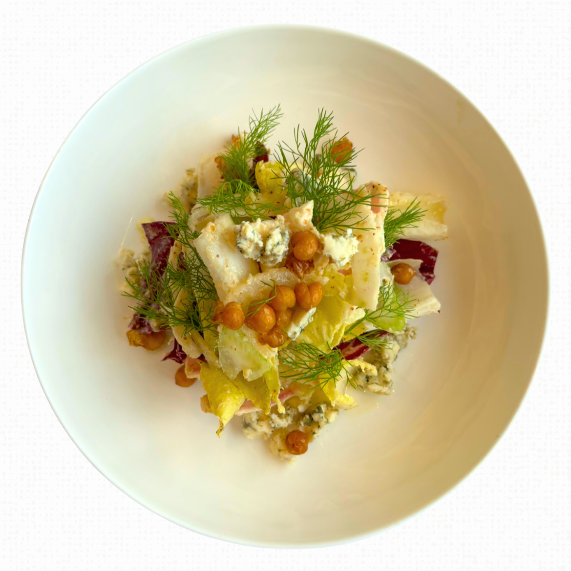 A white plate of Haven Green on a white tablecloth-covered table. 