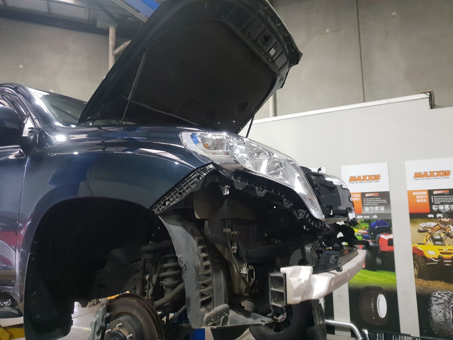 Blue Car in A Workshop with Front End Damage, Hood Open — Autoplus Picton in Picton, NSW