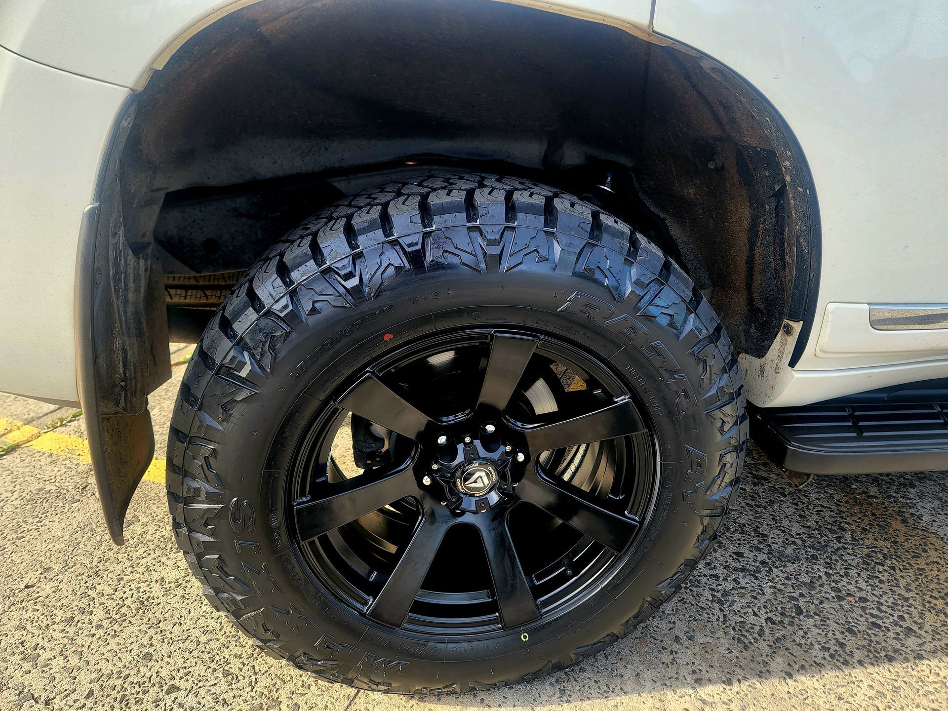 Black Tire and Rim on A White Car, Under the Wheel Well — Autoplus Picton in Picton, NSW